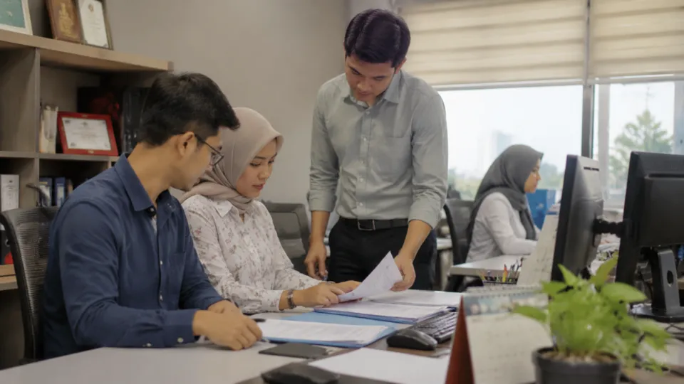 Administrative professionals coordinating documents in an office